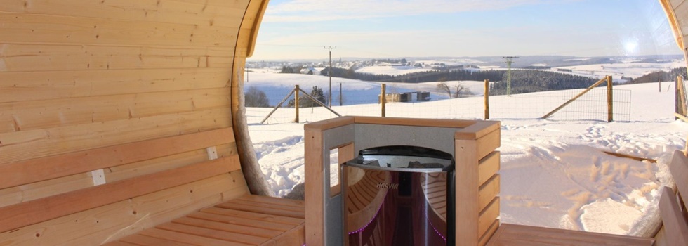 Sauna im Schnee mit Panorama Scheibe